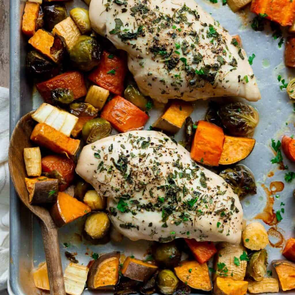 healthy sheet pan chicken and veggies including Brussels sprouts, carrots, sweet potatoes, and parsnips