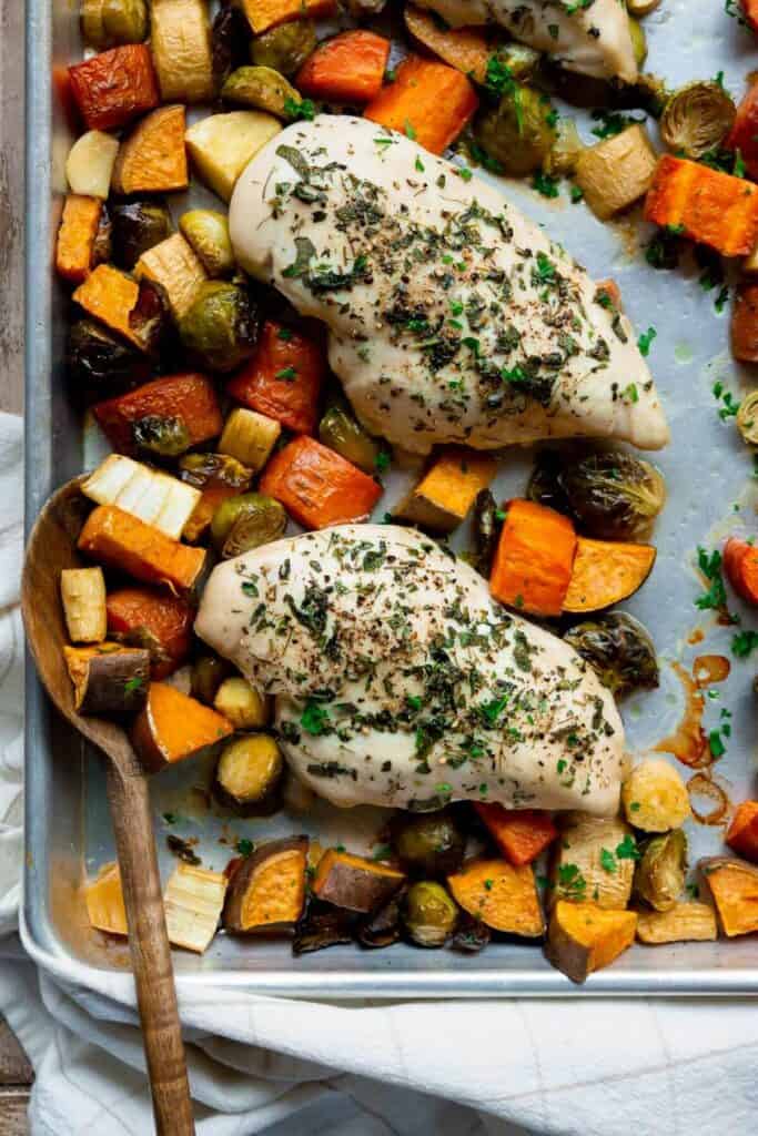 sheet pan chicken and veggies including Brussels sprouts, carrots, sweet potatoes, and parsnips