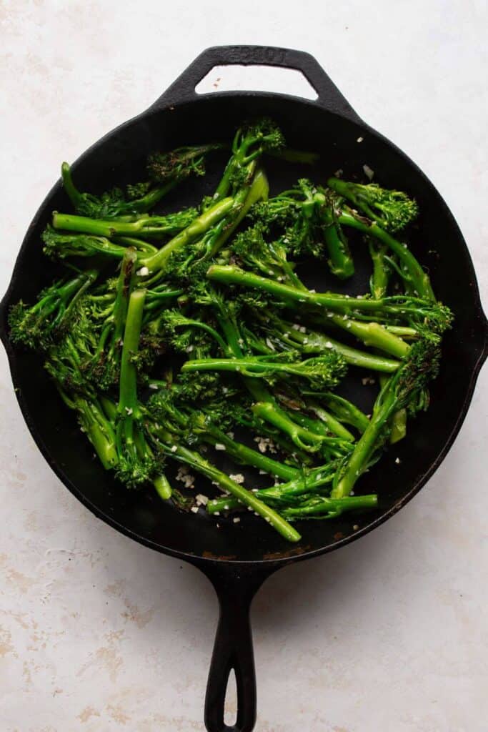 sautéing broccolini in a cast iron pan with garlic