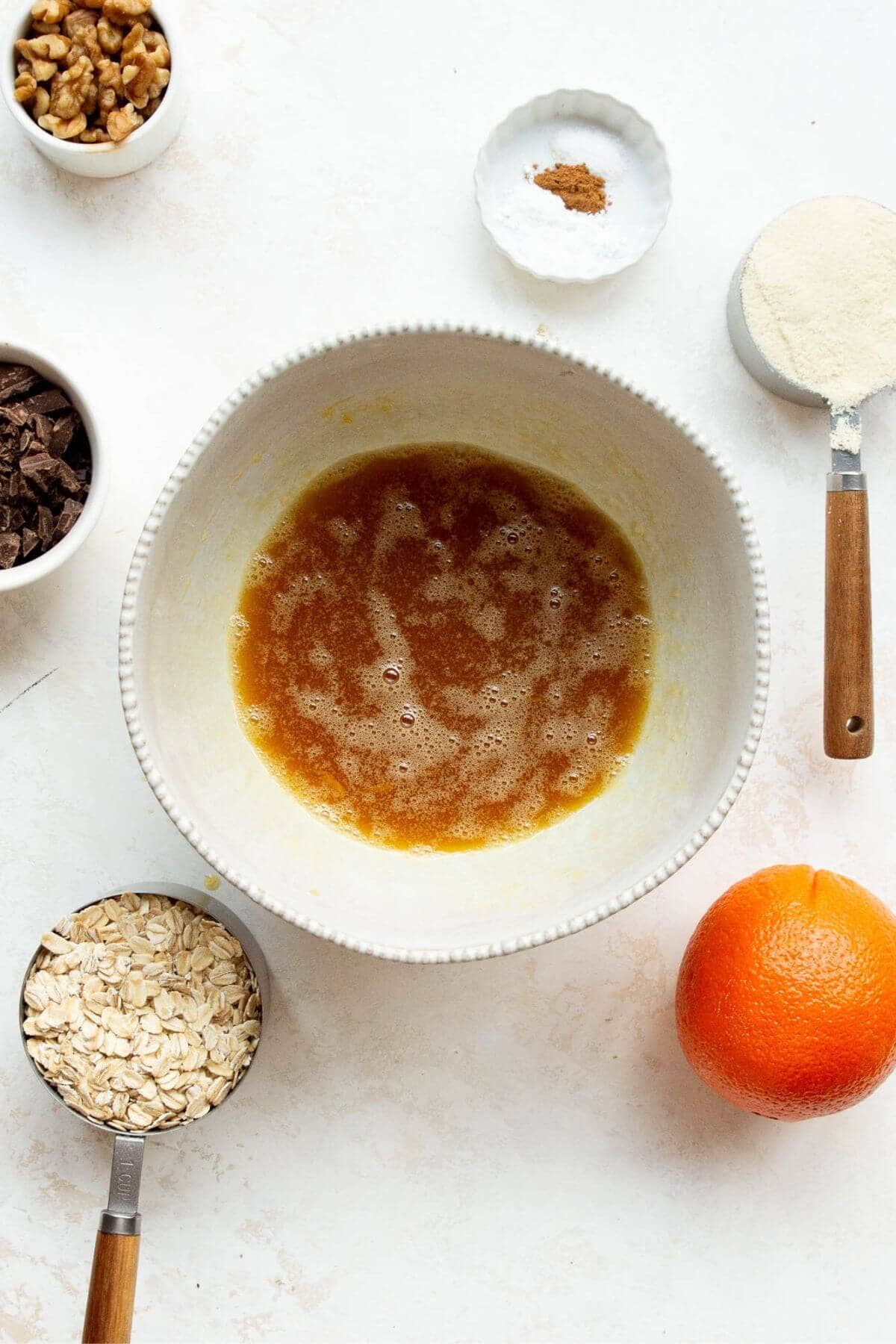 Egg, maple syrup, coconut oil, and vanilla whisked together in a mixing bowl.