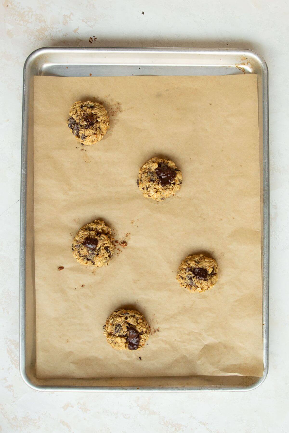 Golden brown orange oatmeal cookies on a baking sheet after baking.