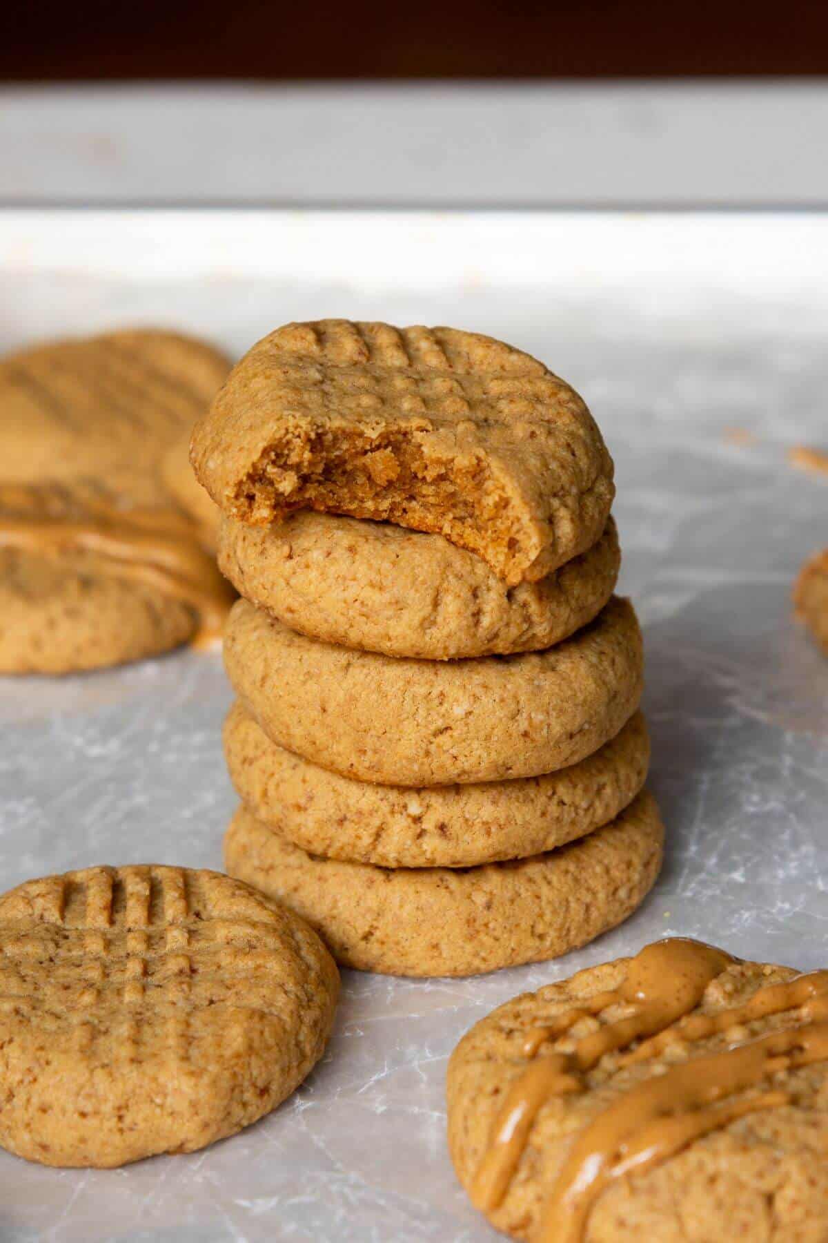 Stack of soft and chewy almond flour peanut butter cookies showing their tender, slightly gooey centers.