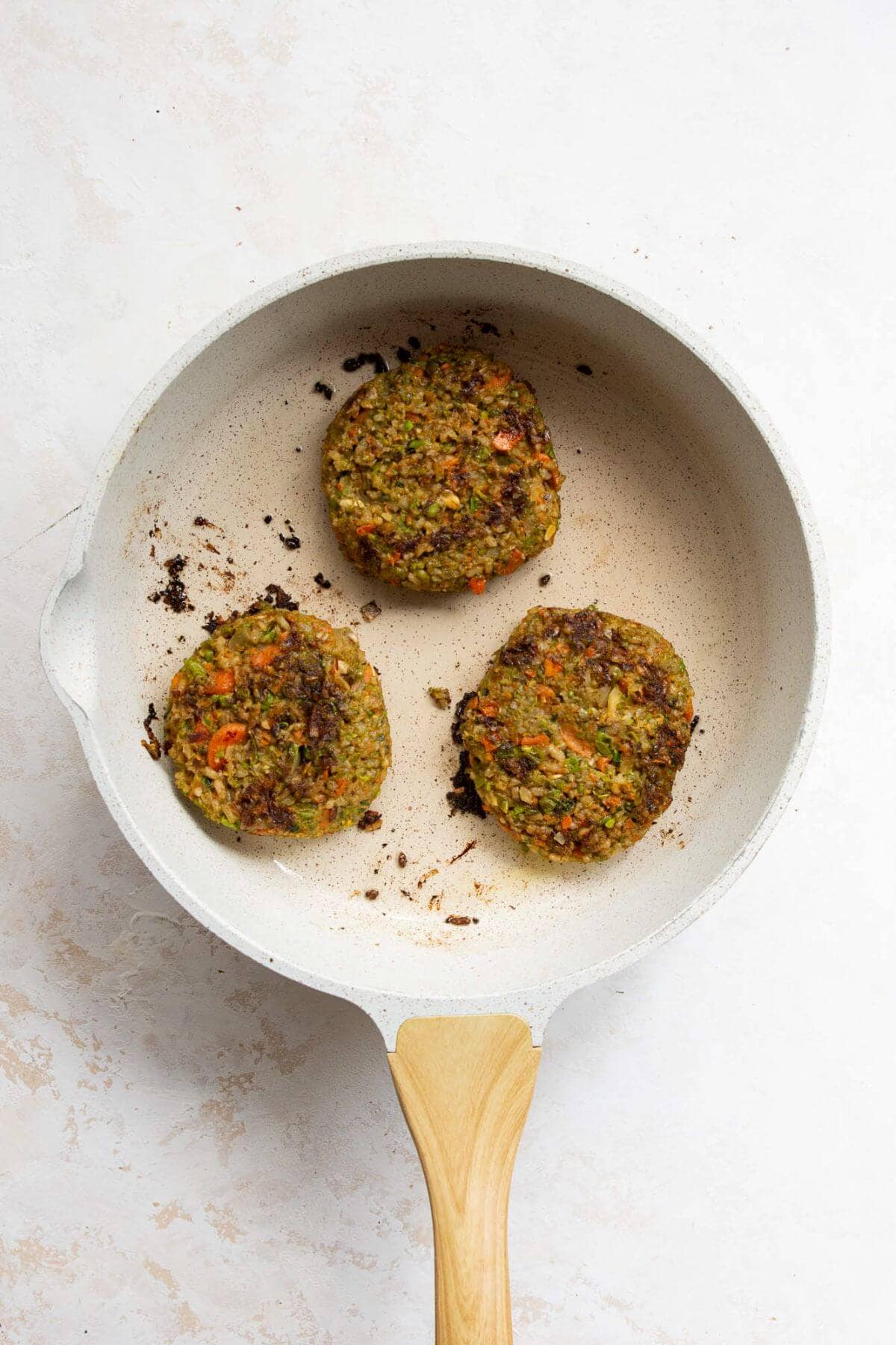cooking crispy veggie burgers in a pan