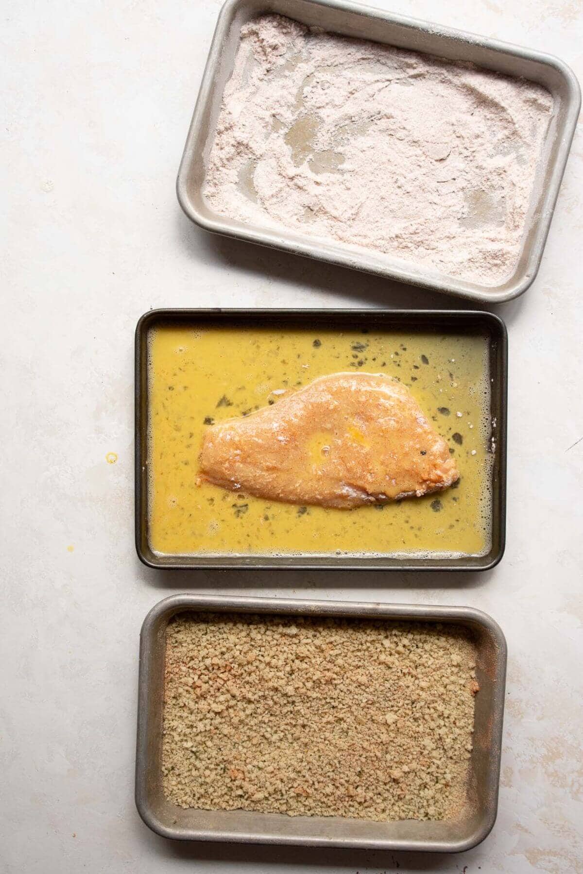 Dipping same chicken cutlet in egg wash.