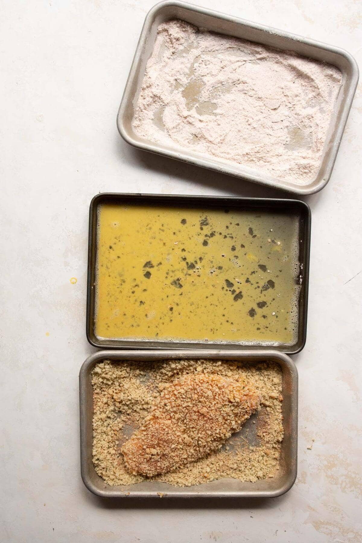 Coating chicken cutlet with panko breadcrumbs.