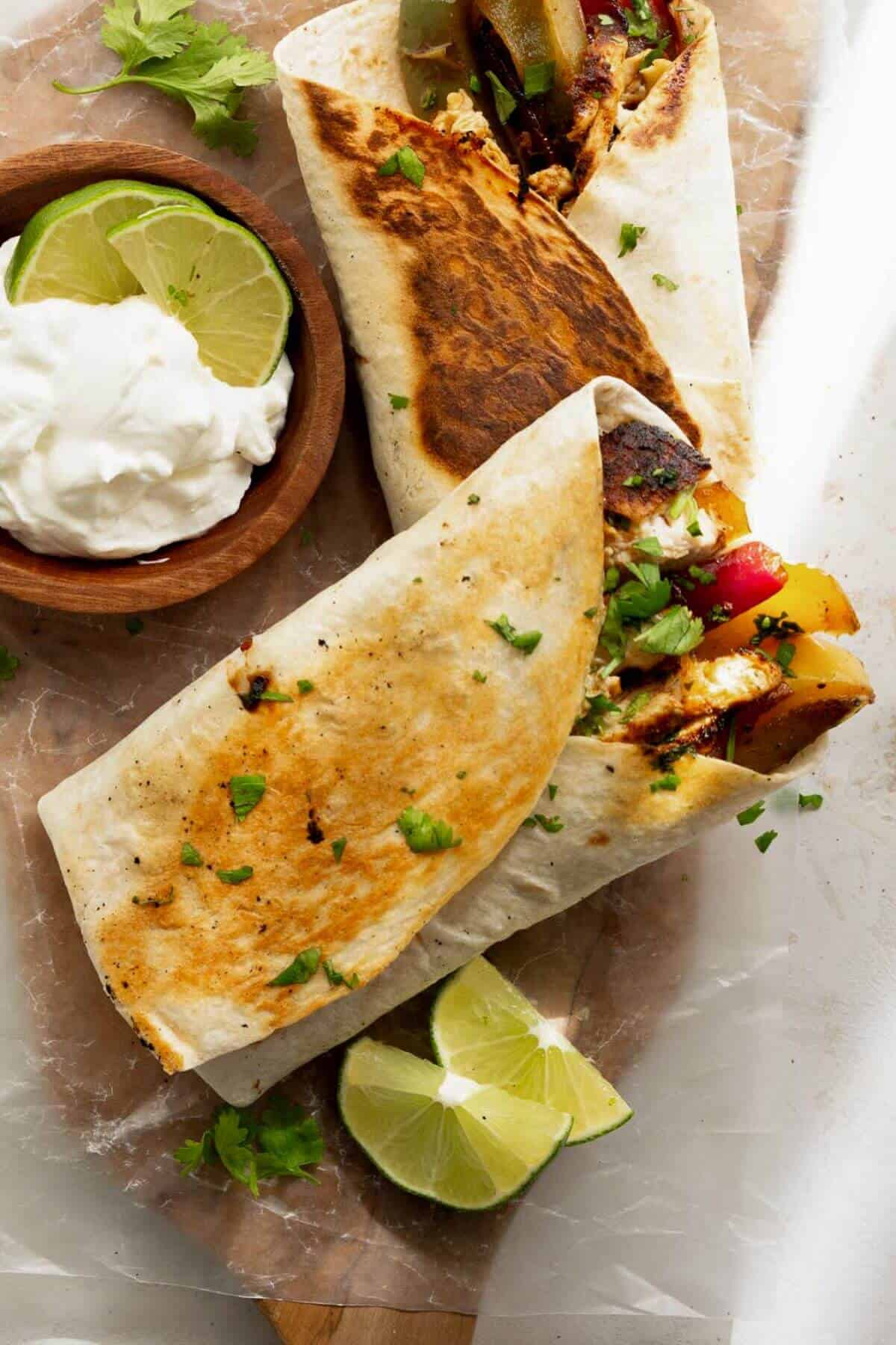crispy chicken fajitas wraps filling with fajita veggies, taco seasoned chicken, cheese, and sour cream