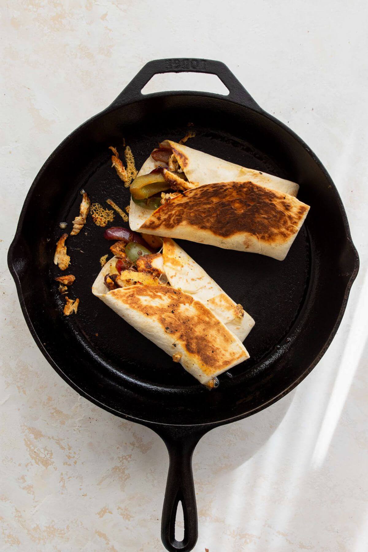 Searing the wrap in a greased skillet for 1–2 minutes per side until golden and crispy