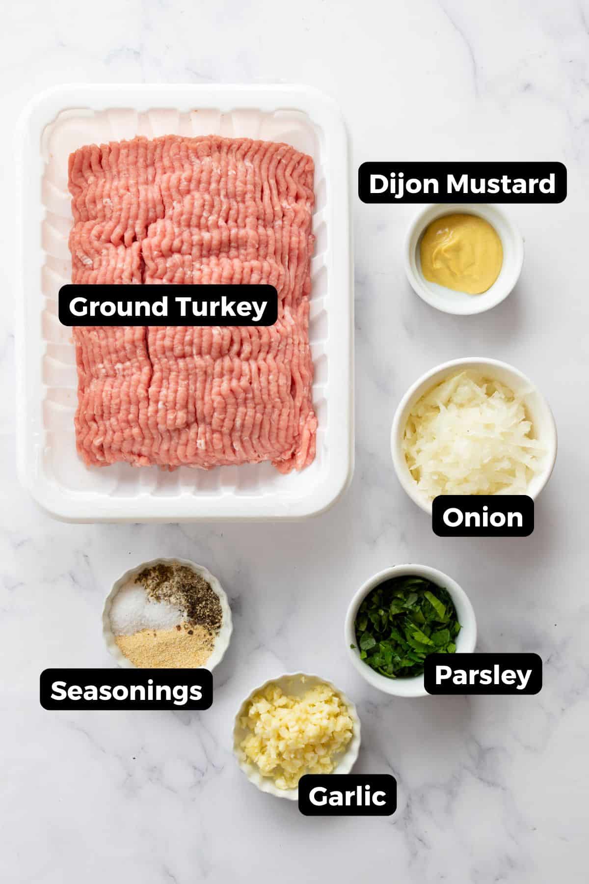 Ingredients for grilled turkey burgers including ground turkey, Dijon mustard, grated onion, parsley, garlic, and seasonings.