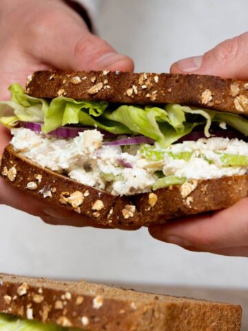 Healthy cottage cheese chicken salad without mayo served on a sandwich with lettuce and red onion.