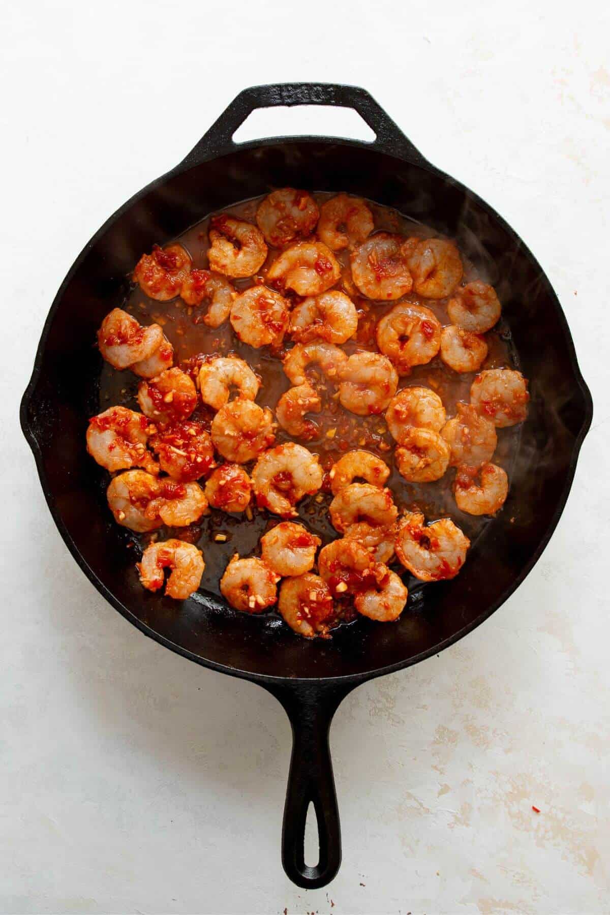 adding the shrimp in a single layer to a hot cast iron skillet