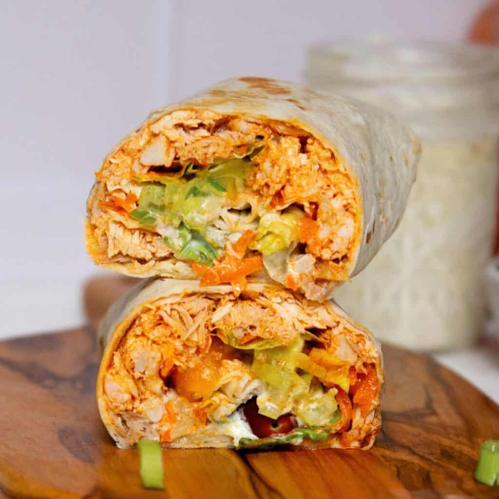 Healthy and high protein buffalo chicken Caesar wraps with homemade Greek yogurt Caesar dressing, avocado, and lettuce.