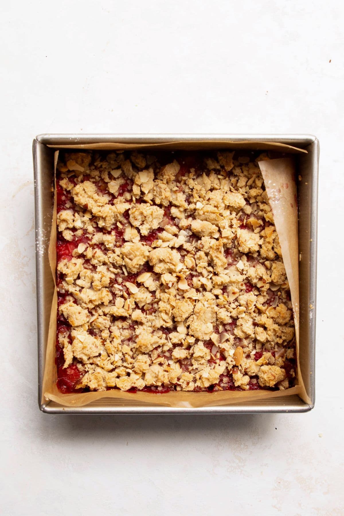 baked strawberry bars in the baking dish with a soft oatmeal crumble streusel on top
