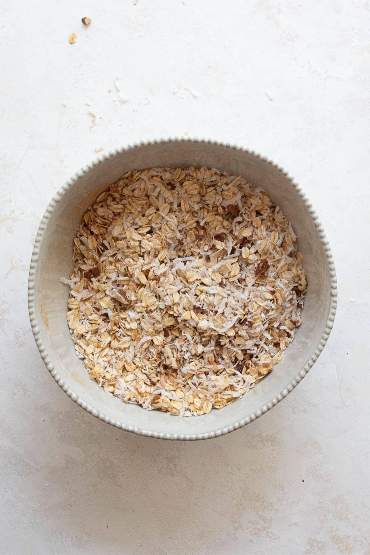 rolled oats, shredded coconut, salt, and pecans in a mixing bowl