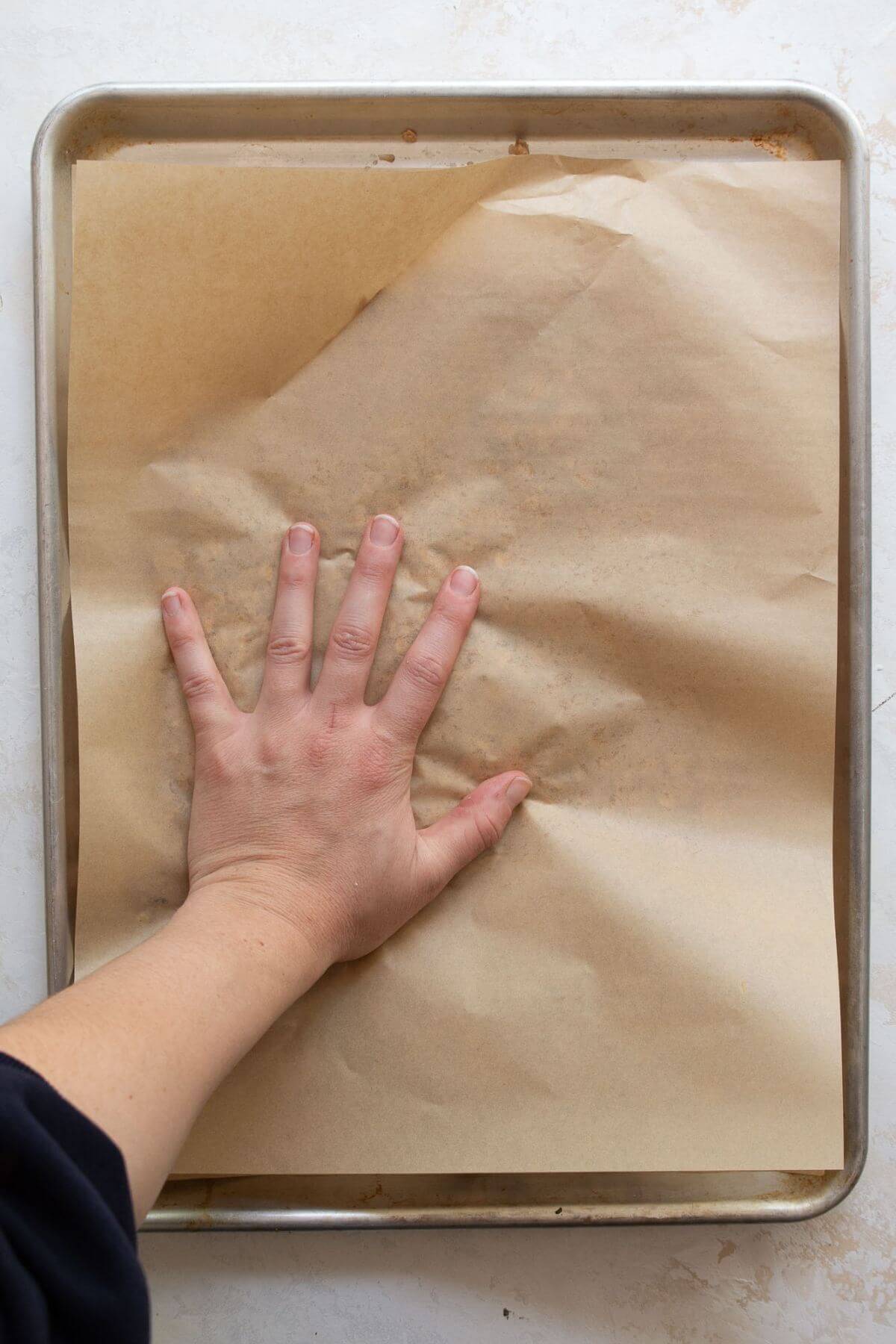 how to make the chunkiest homemade granola by pressing it down with parchment paper