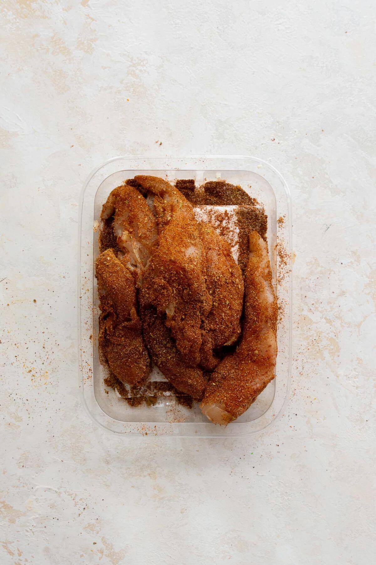 Chicken tenders coated in homemade blackened seasoning blend for healthy chicken fajita bowls.