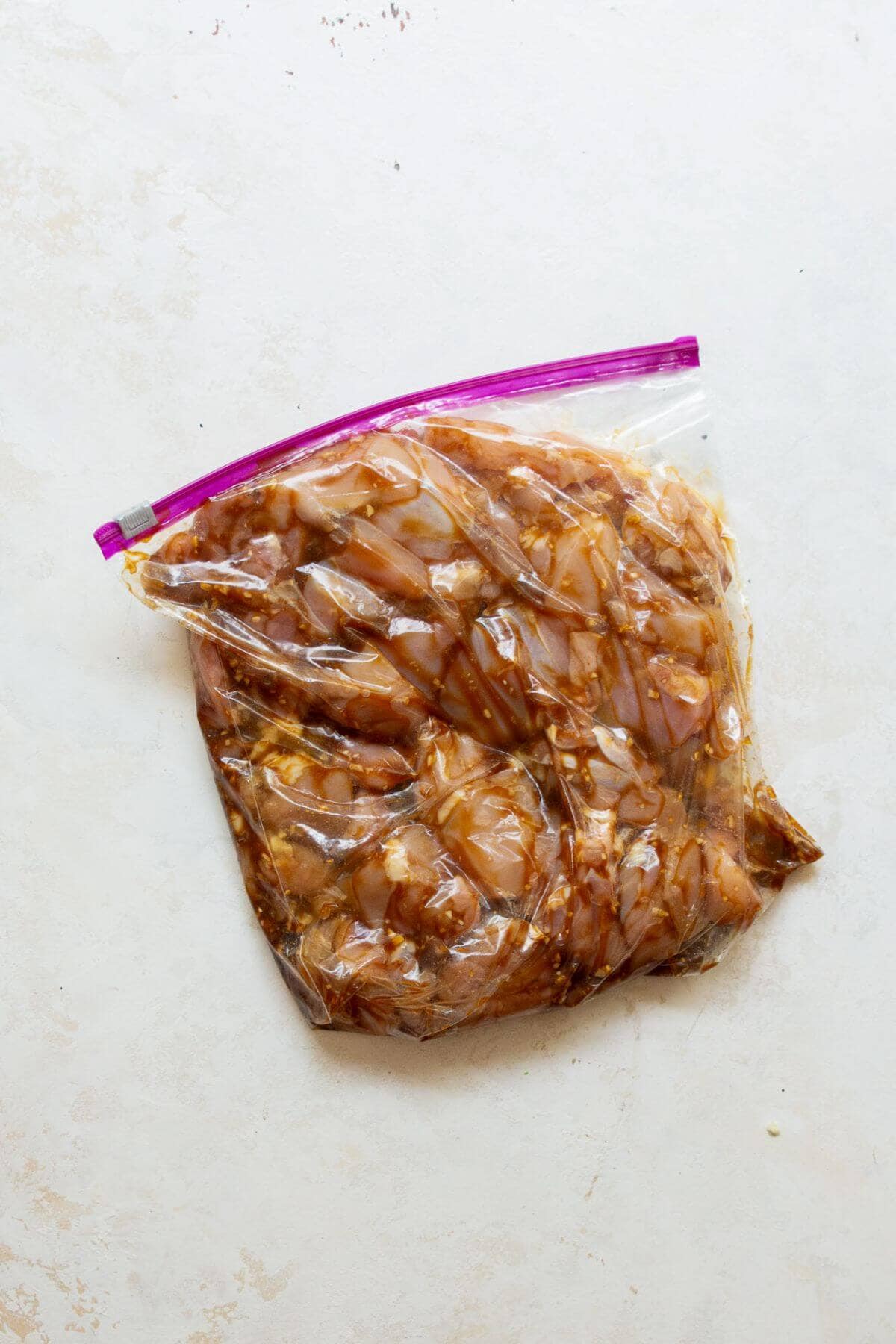Chicken pieces marinating in honey soy miso sauce inside a zip-top bag