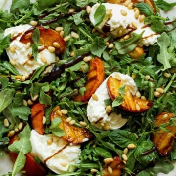 Easy Summer time grilled peach and burrata salad with fresh basil, arugula, pine nuts, and balsamic glaze
