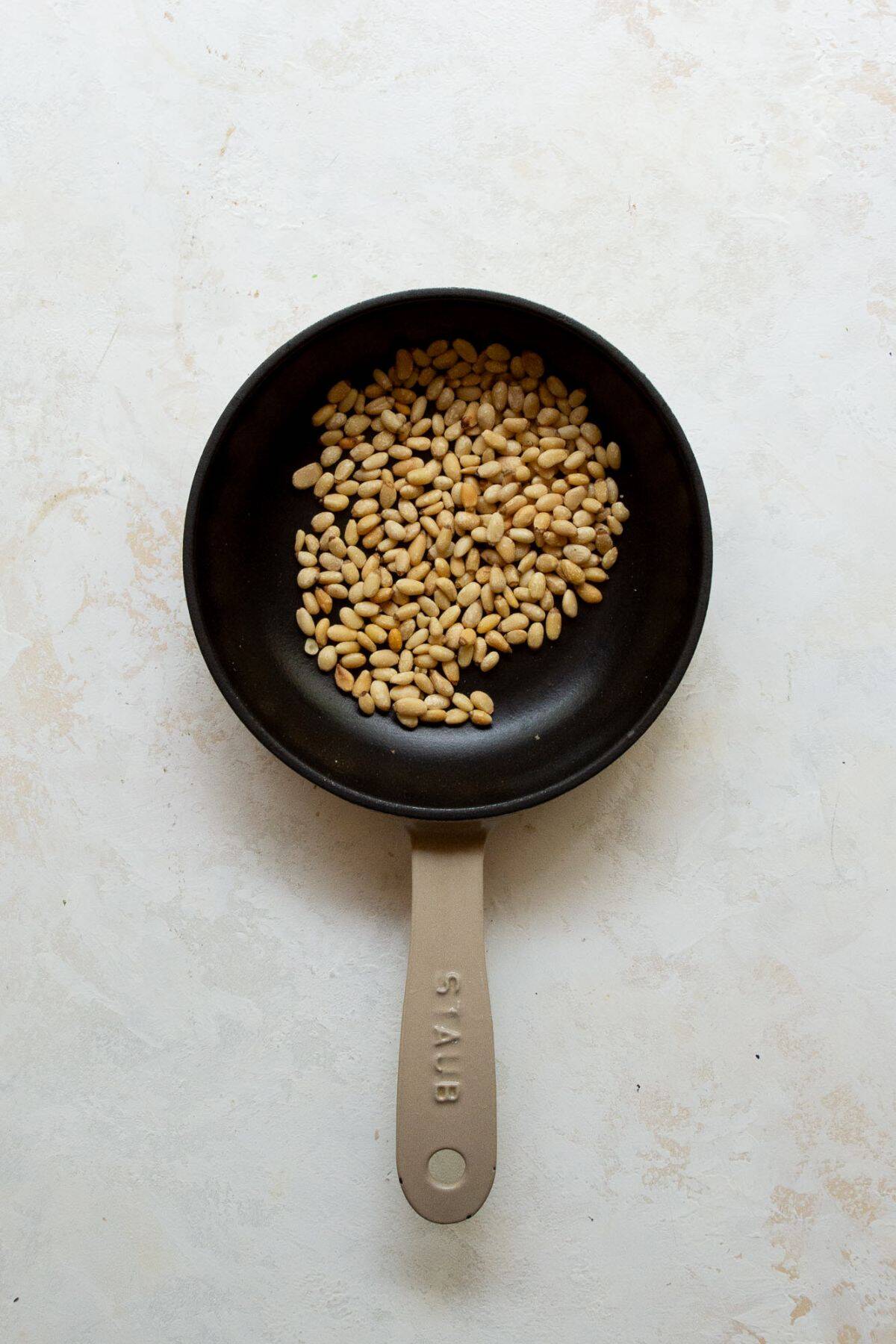 toasting pine nuts in a pan