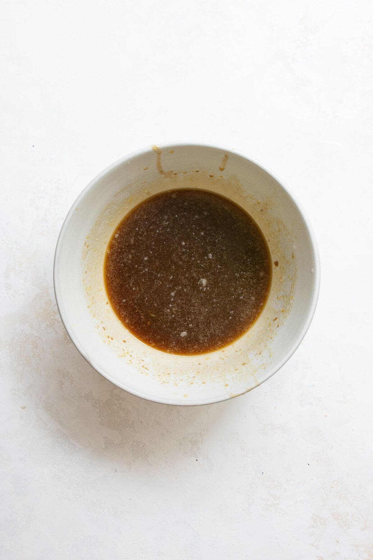 Whisked eggs, melted coconut oil, coconut sugar, maple syrup, and vanilla extract in a large mixing bowl.