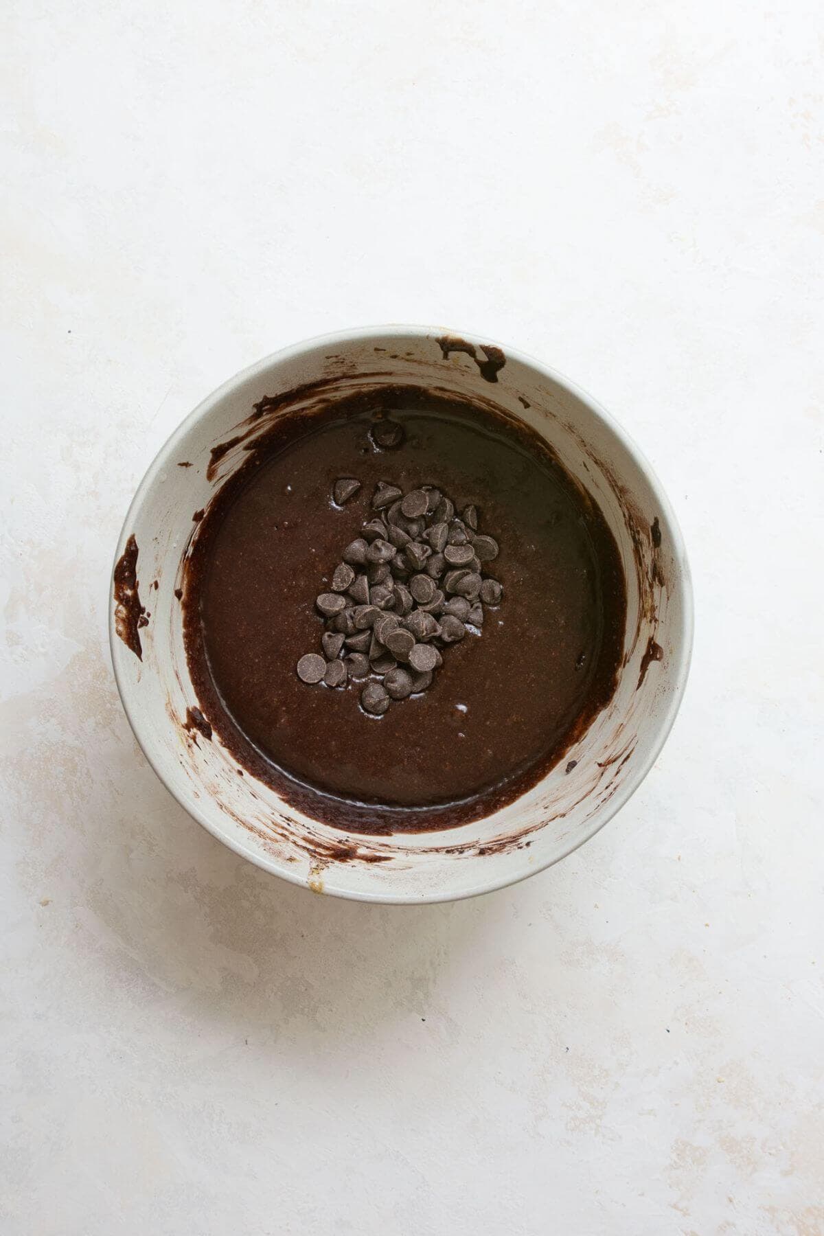 Adding chocolate chips to the brownie batter bowl.