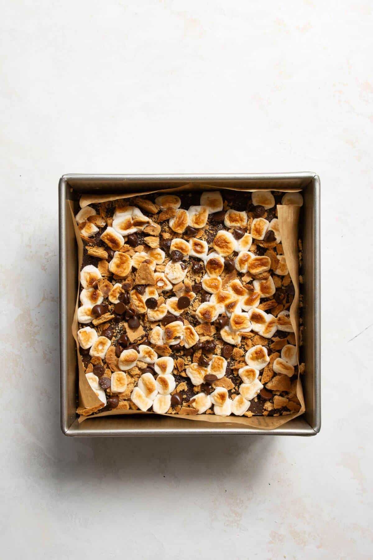 Adding mini marshmallows, chocolate chips, and crushed graham crackers on top of brownies and broiling to melt and toast.