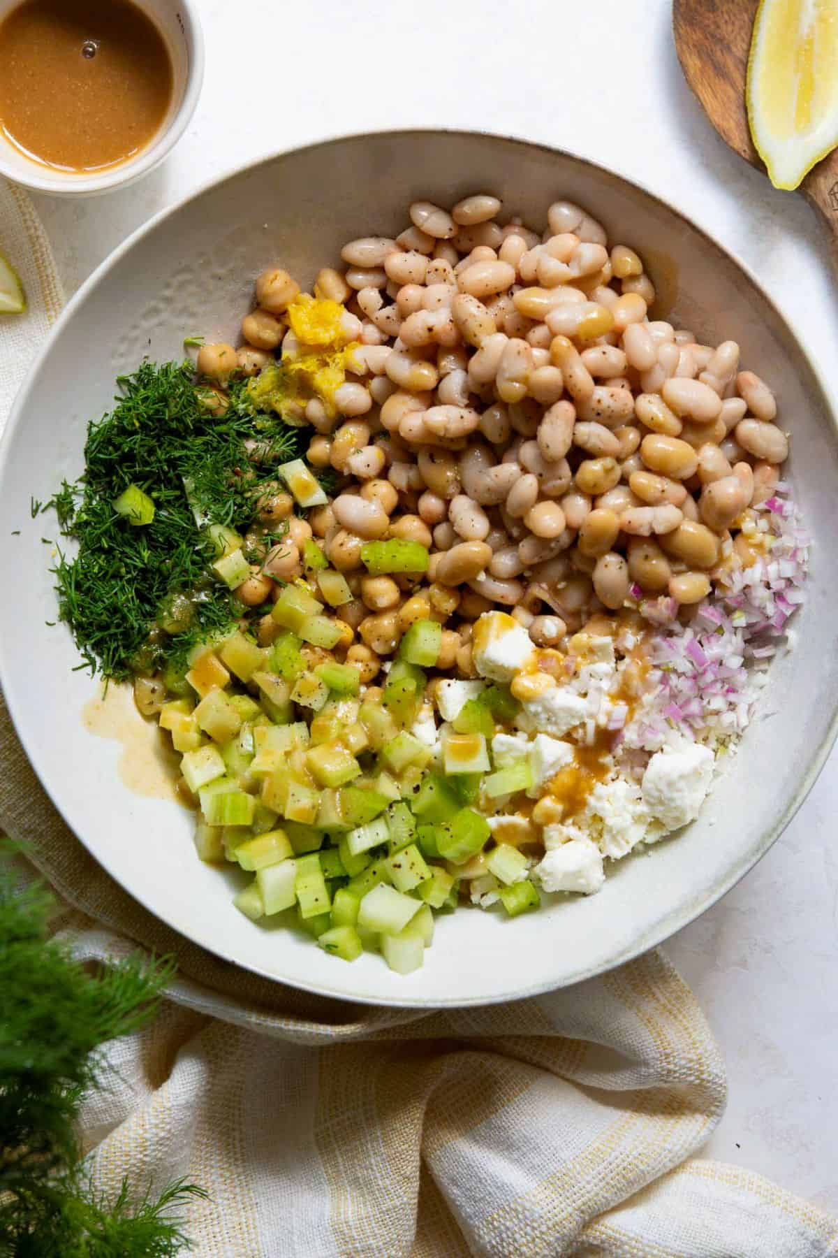 Mediterranean dense bean salad with dressing drizzled on top.