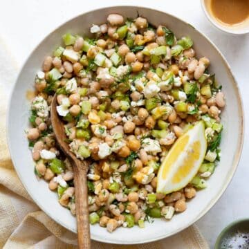 Easy Mediterranean dense bean salad made with chickpeas, white beans, lemon zest, dill, shallots, feta, and a tangy Dijon-honey vinaigrette.