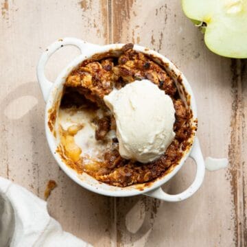 Healthy single-serve air fryer apple crisp with warm, bubbling cinnamon apples topped with a golden, buttery oat crumble.
