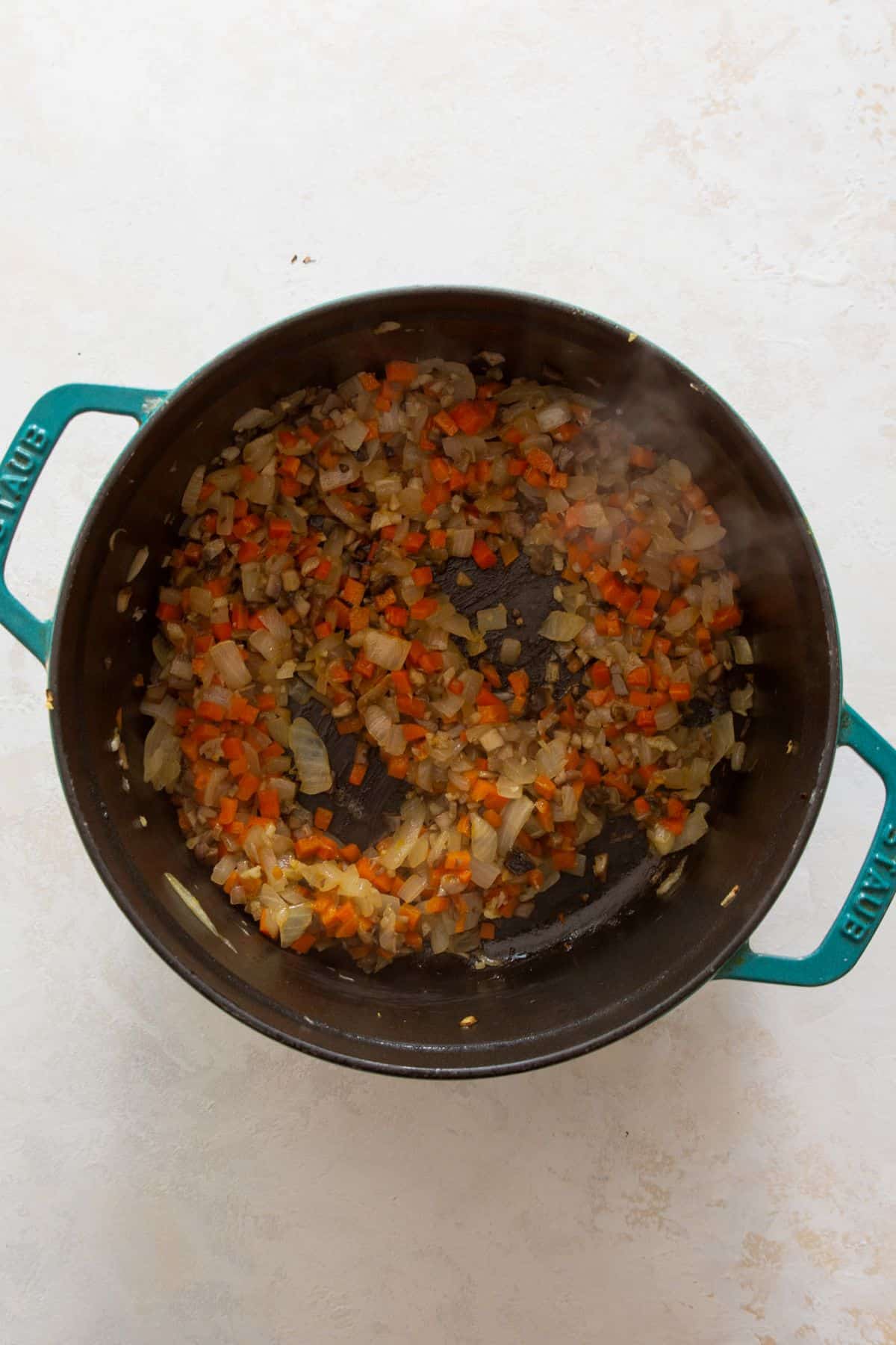 Sautéed carrots, onions, mushrooms, and garlic cooked down and golden brown for rich flavor base for healthy chicken bolognese sauce.
