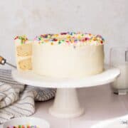 Soft, moist healthy vanilla birthday cake sweetened with maple syrup and topped with light vanilla buttercream and colorful sprinkles.