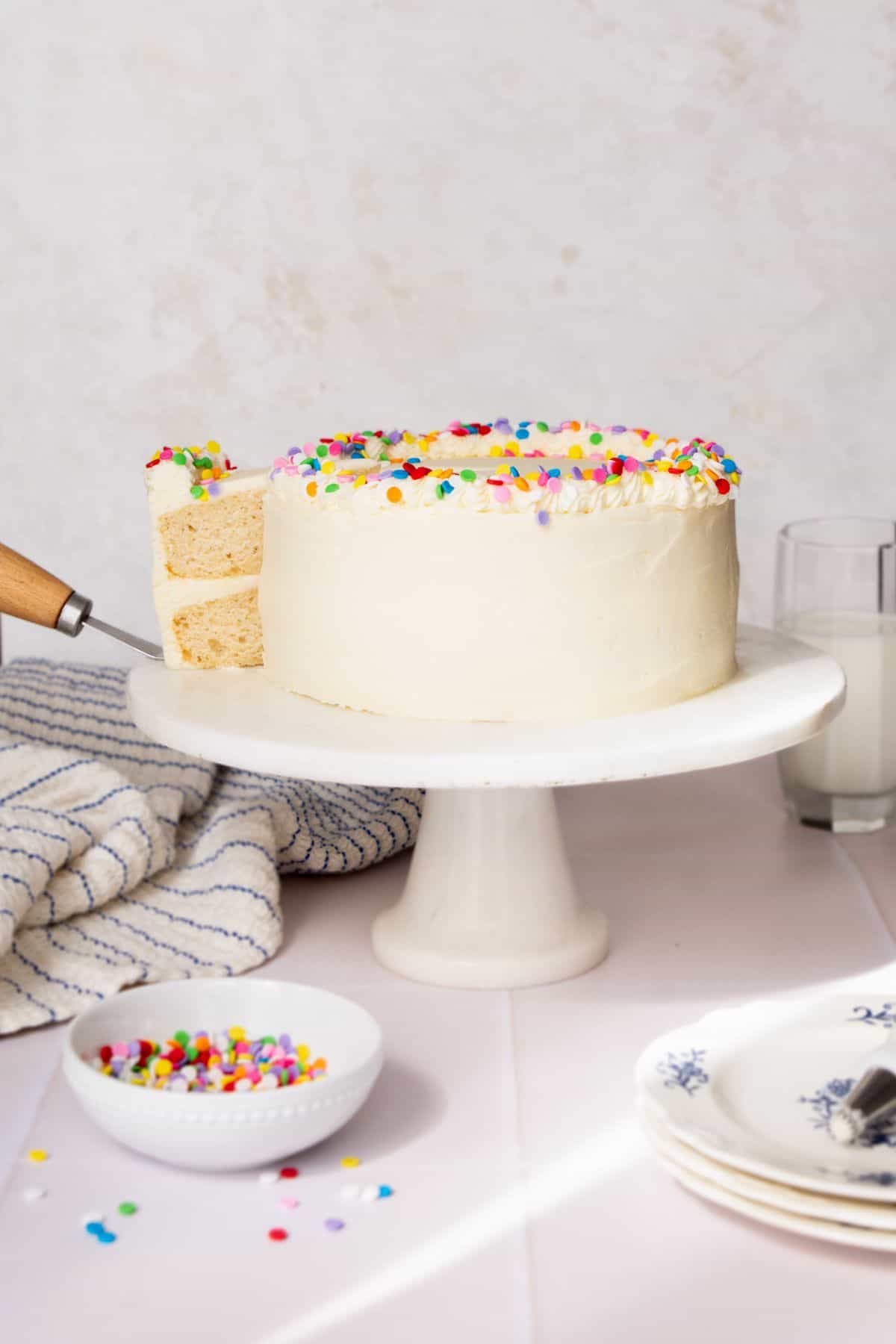 Healthy vanilla birthday cake made with Greek yogurt, maple syrup, and egg whites, topped with lightened-up vanilla buttercream and sprinkles.