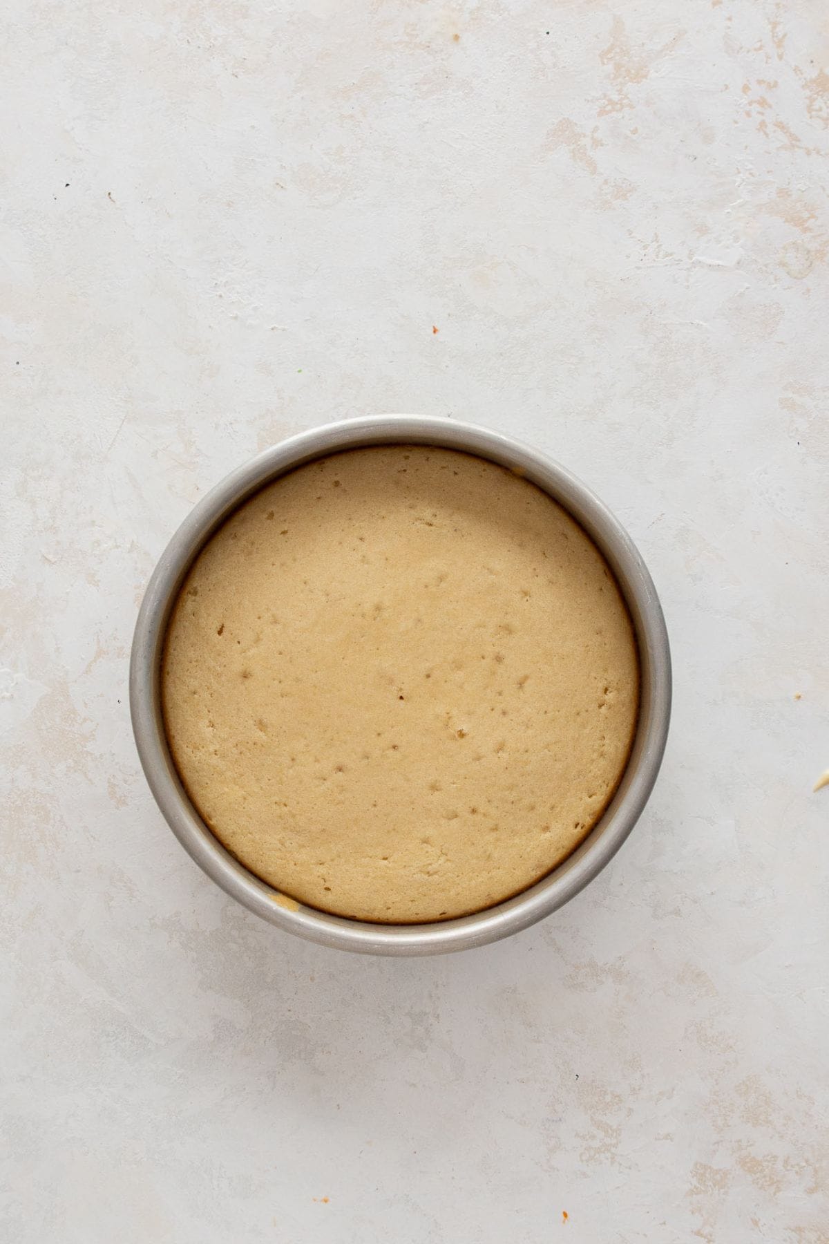 Baking healthy vanilla cake layers in the oven at 350°F until golden and fully set.