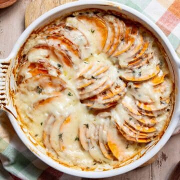 Easy, lightened-up scalloped sweet potatoes with bubbling garlic Gruyère sauce made without heavy cream.