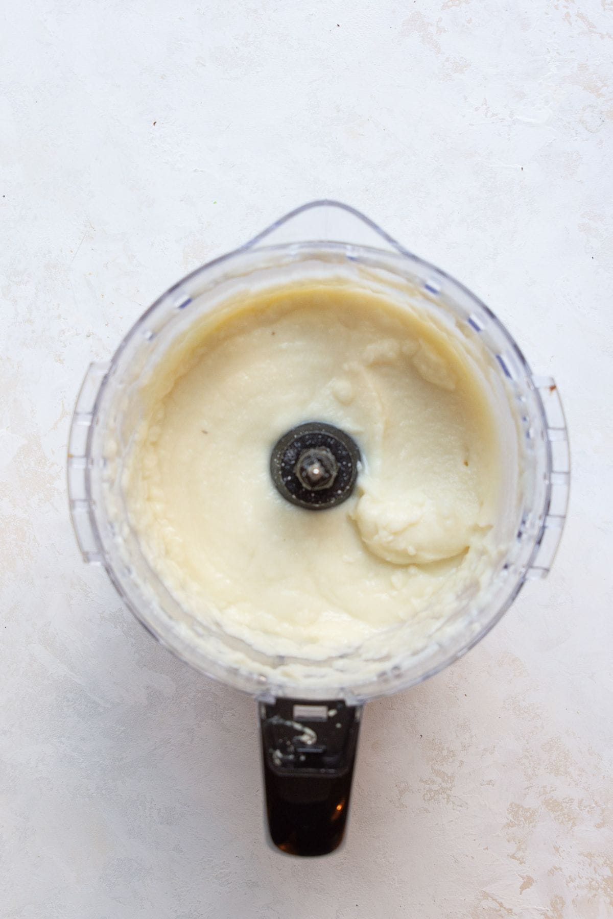 Creamy mashed cauliflower inside a food processor after blending.