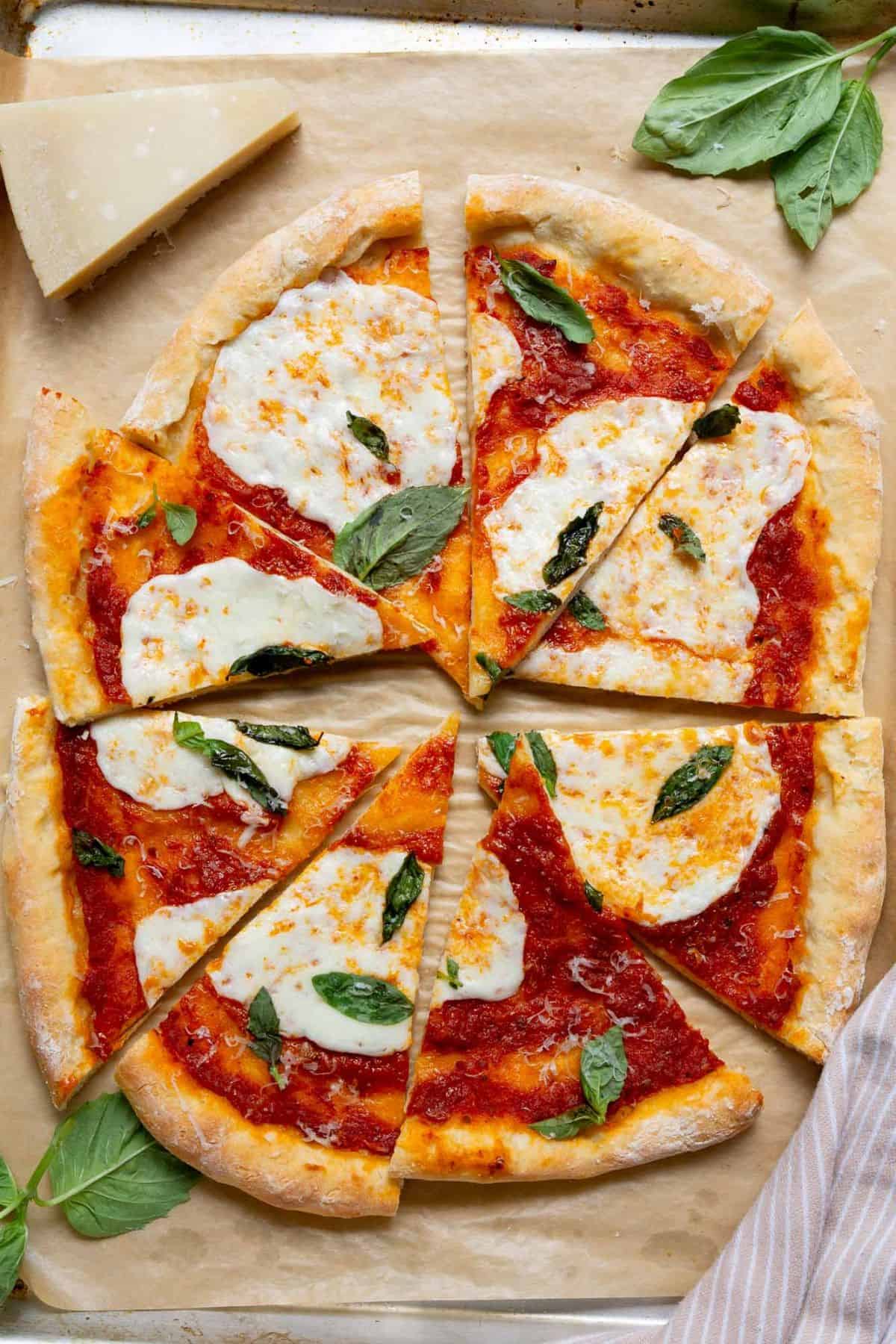 Homemade pizza made with 2-ingredient Greek yogurt pizza dough, topped with marinara, melted mozzarella, and fresh basil.