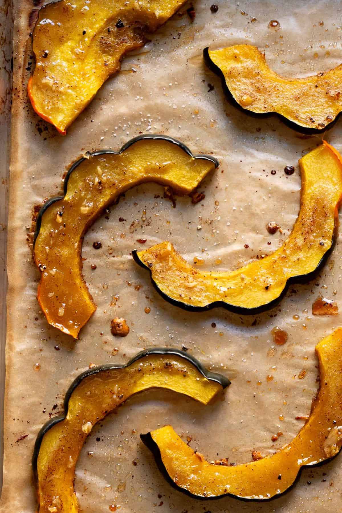 Easy, caramelized roasted acorn squash slices brushed with warm maple syrup, olive oil, garlic, and a touch of cinnamon.