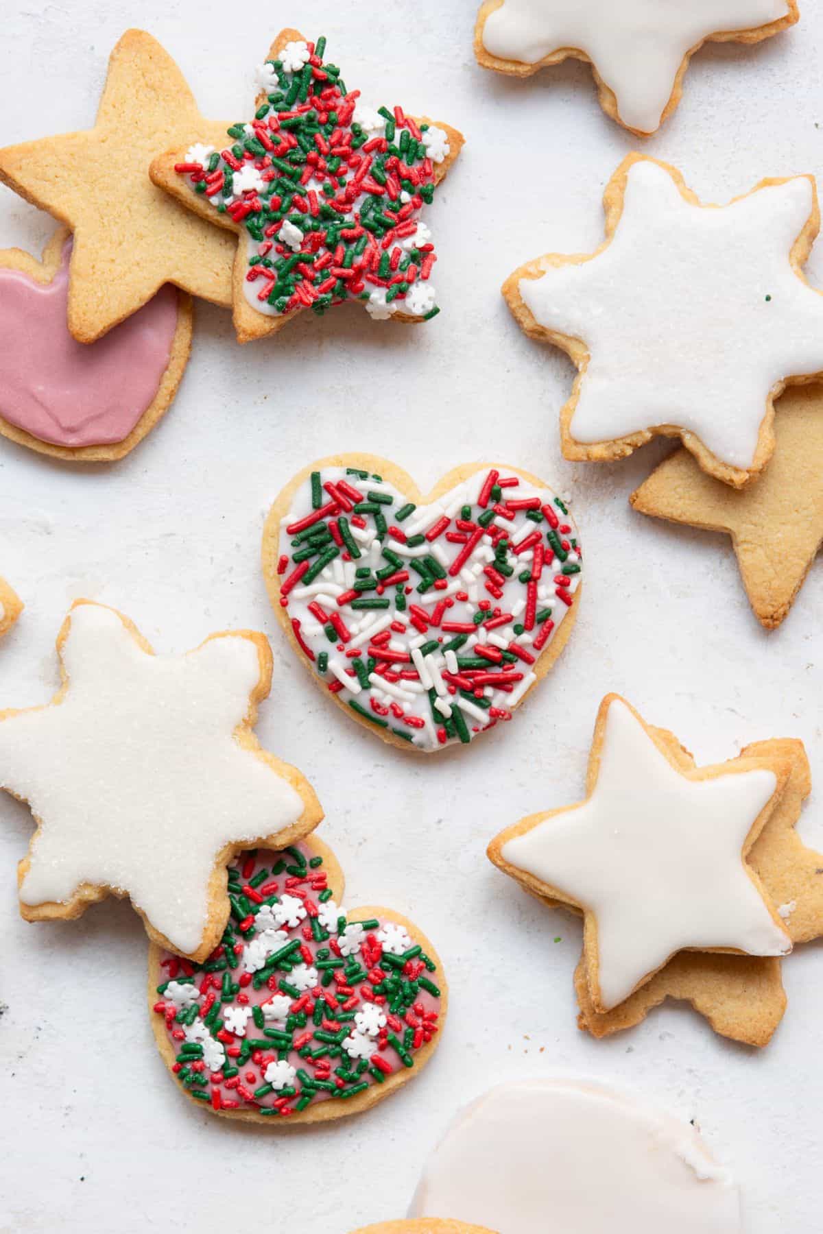 Iced star and heart almond flour sugar cookies topped with red and green Christmas sprinkles.