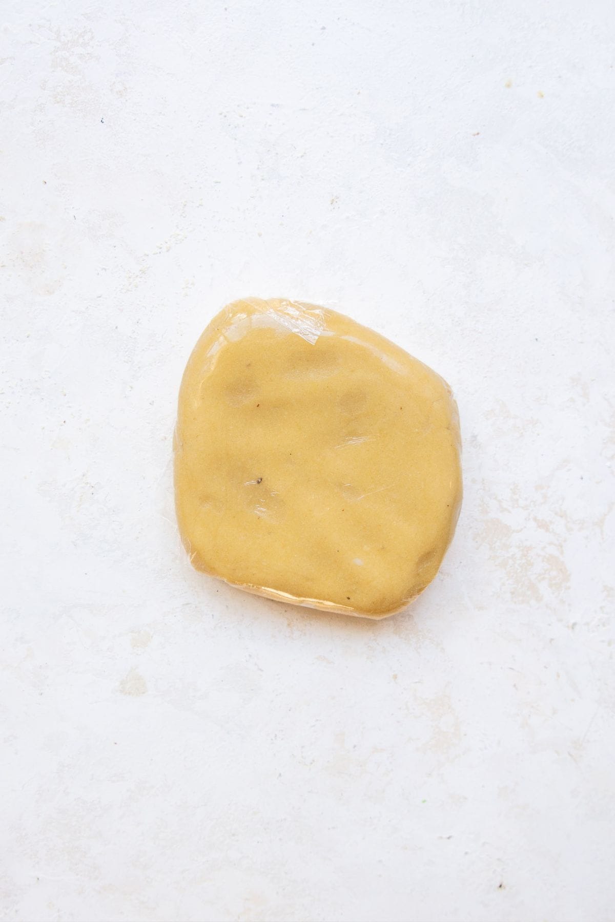 Almond flour sugar cookie dough flattened into a disk.