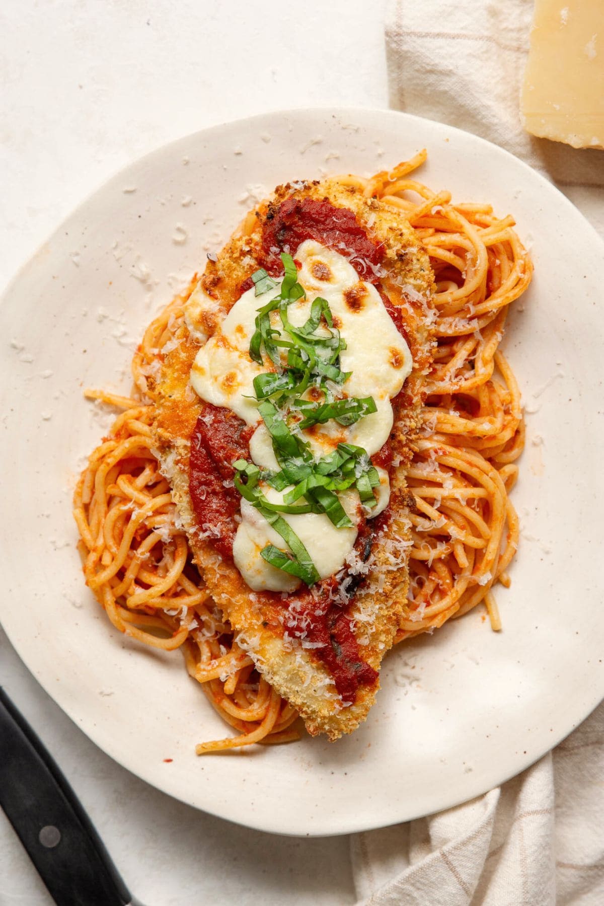 Crispy air fryer chicken parmesan served over spaghetti with melted mozzarella, marinara, and fresh basil.