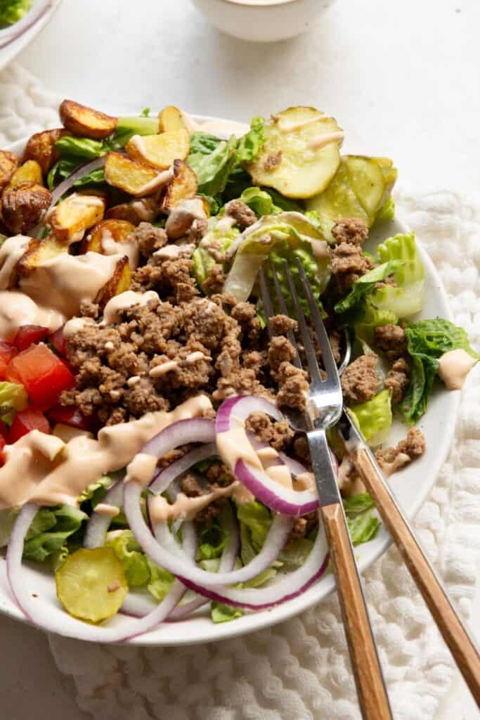 High-protein burger bowl topped with crispy potatoes and tangy special sauce.