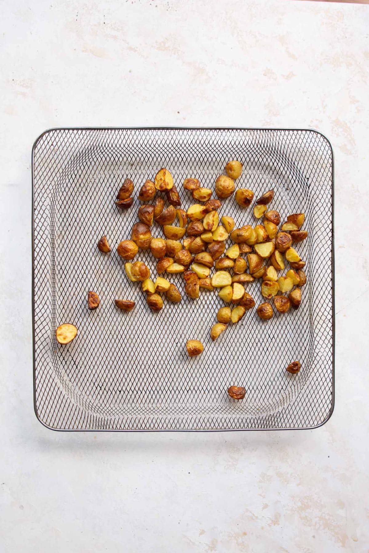 Crispy roasted Yukon gold potatoes on an air fryer tray.