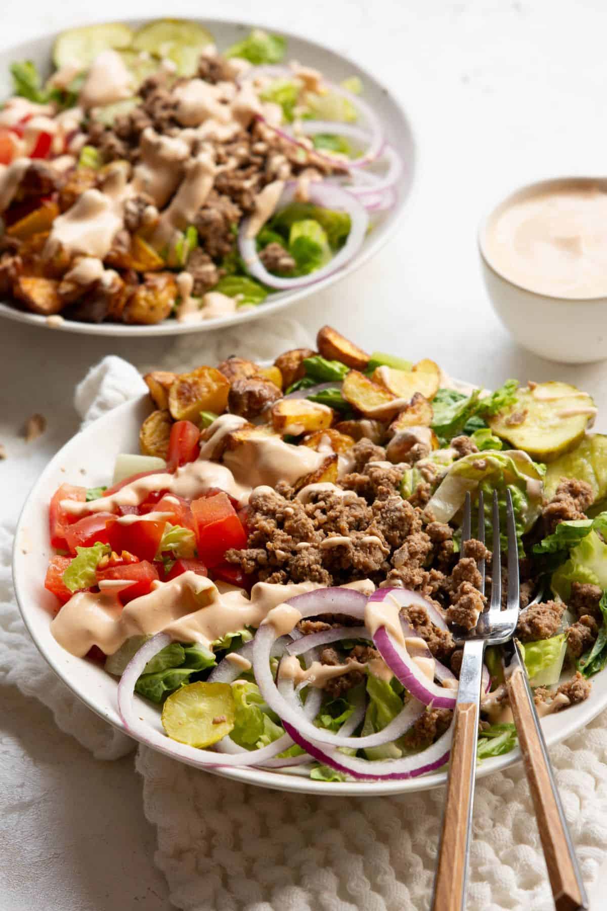 Drizzling greek yogurt special sauce on top of burger bowl.