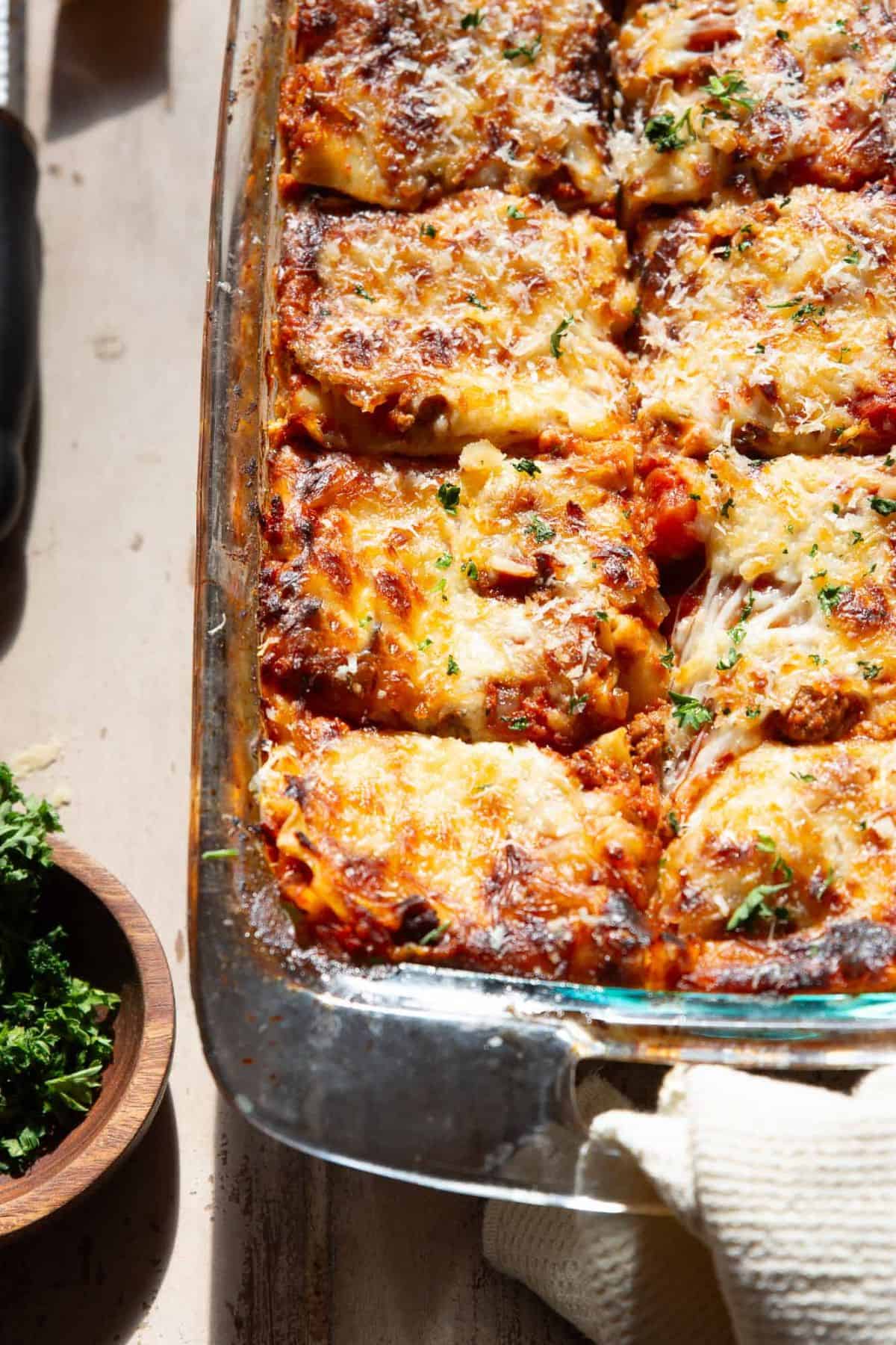 Healthy cottage cheese lasagna cut into squares with browned mozzarella and fresh parsley.
