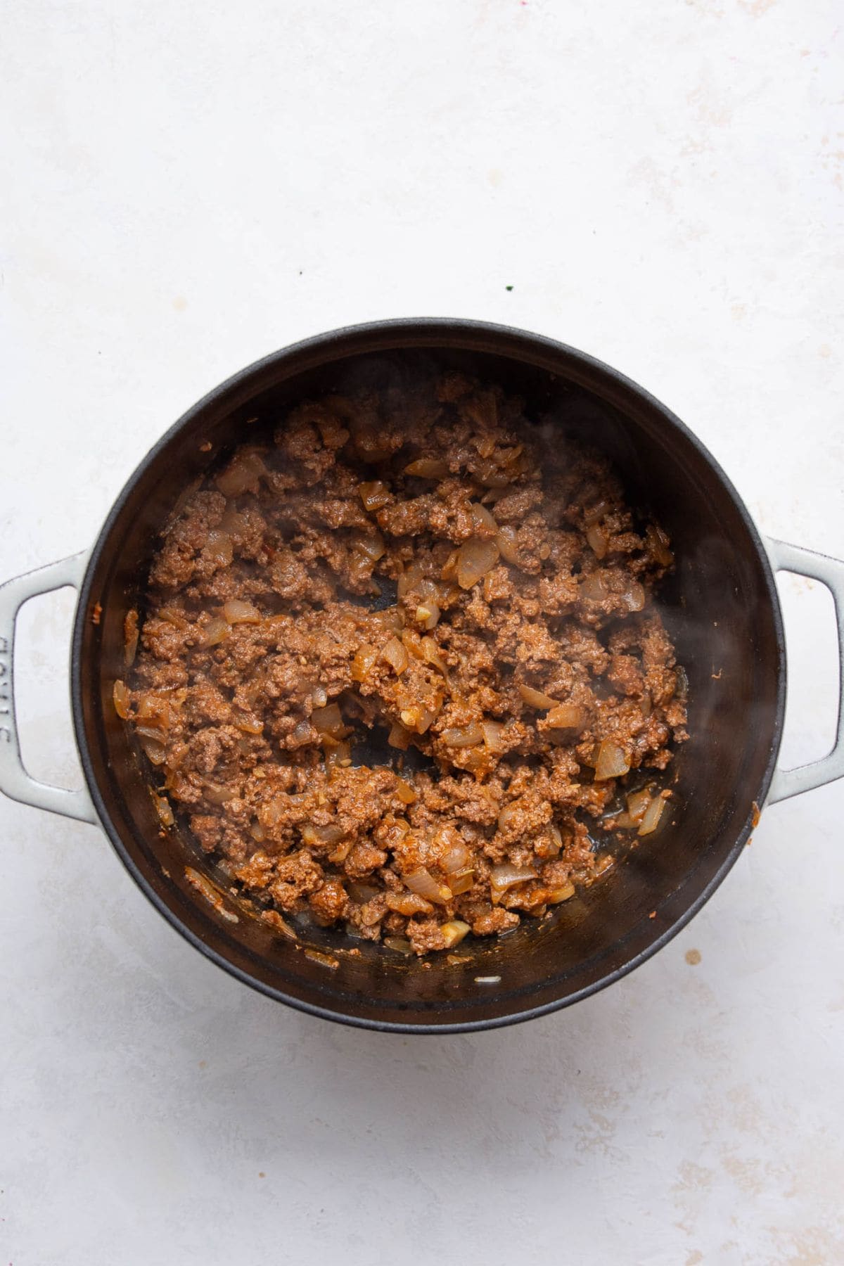 Ground beef cooking with onions in a large pot.