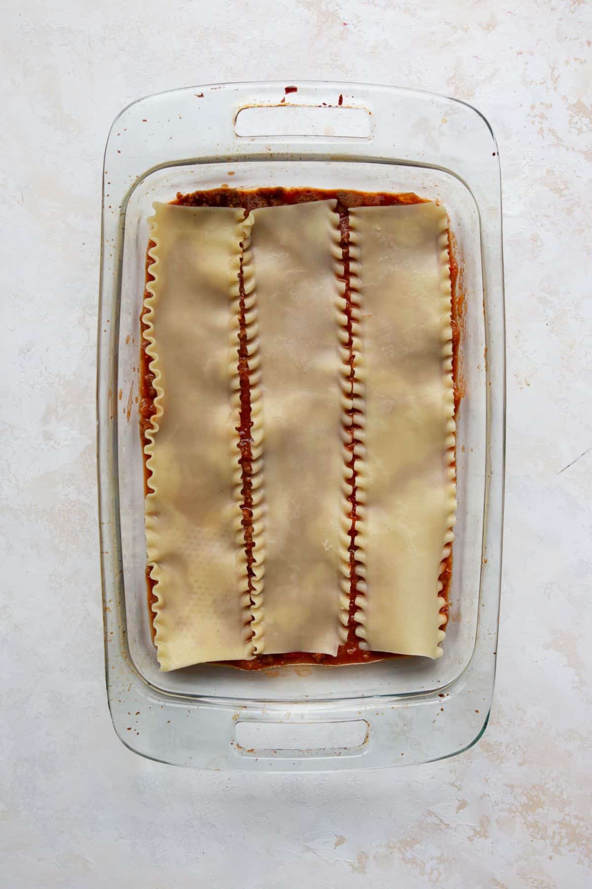 Lasagna noodles layered over meat sauce.