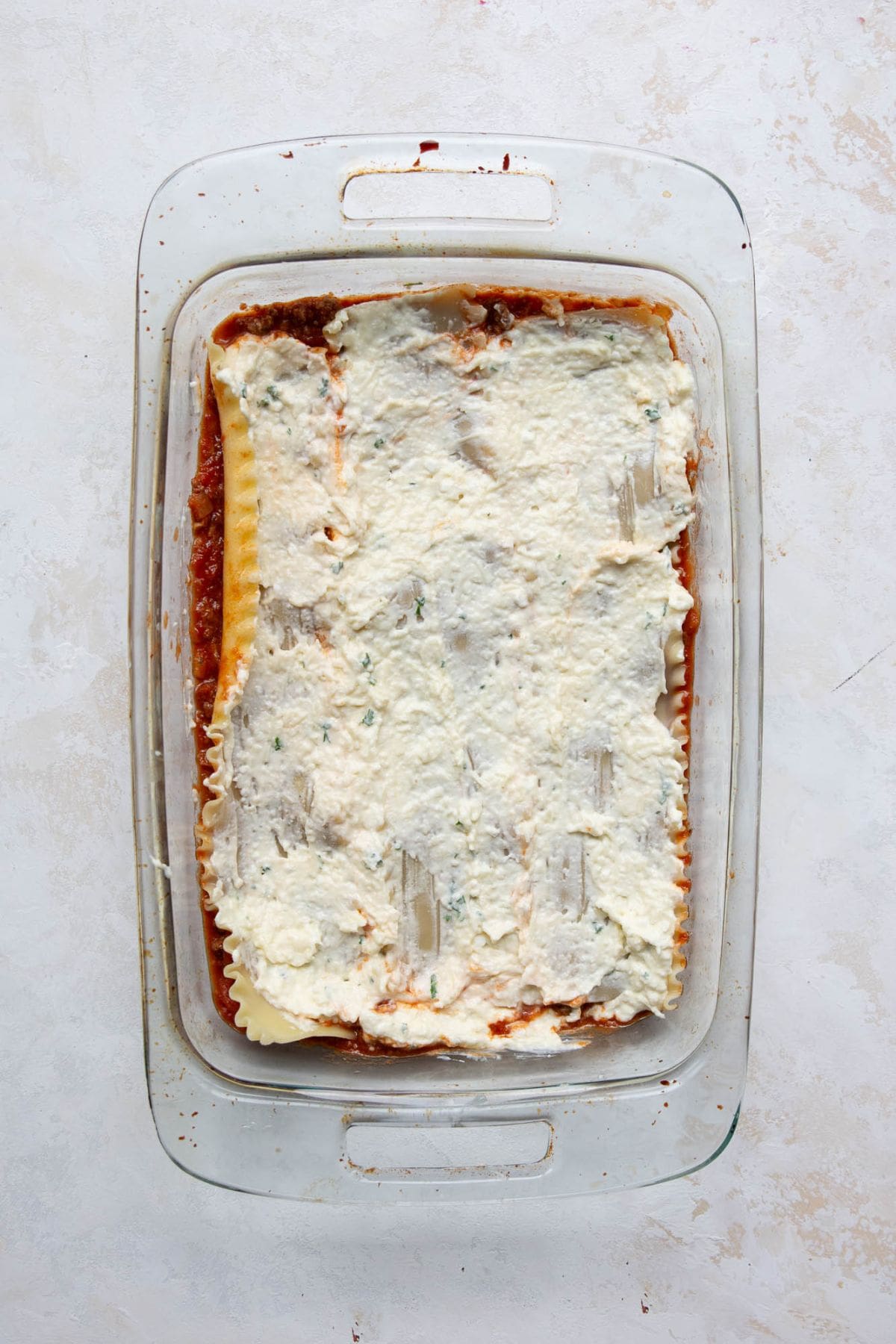 Cottage cheese layer spread evenly over noodles.
