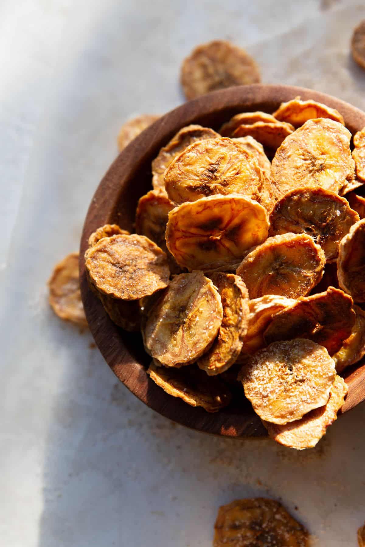A bowl of homemade banana chips, crispy, golden, and air fried until perfectly crunchy.