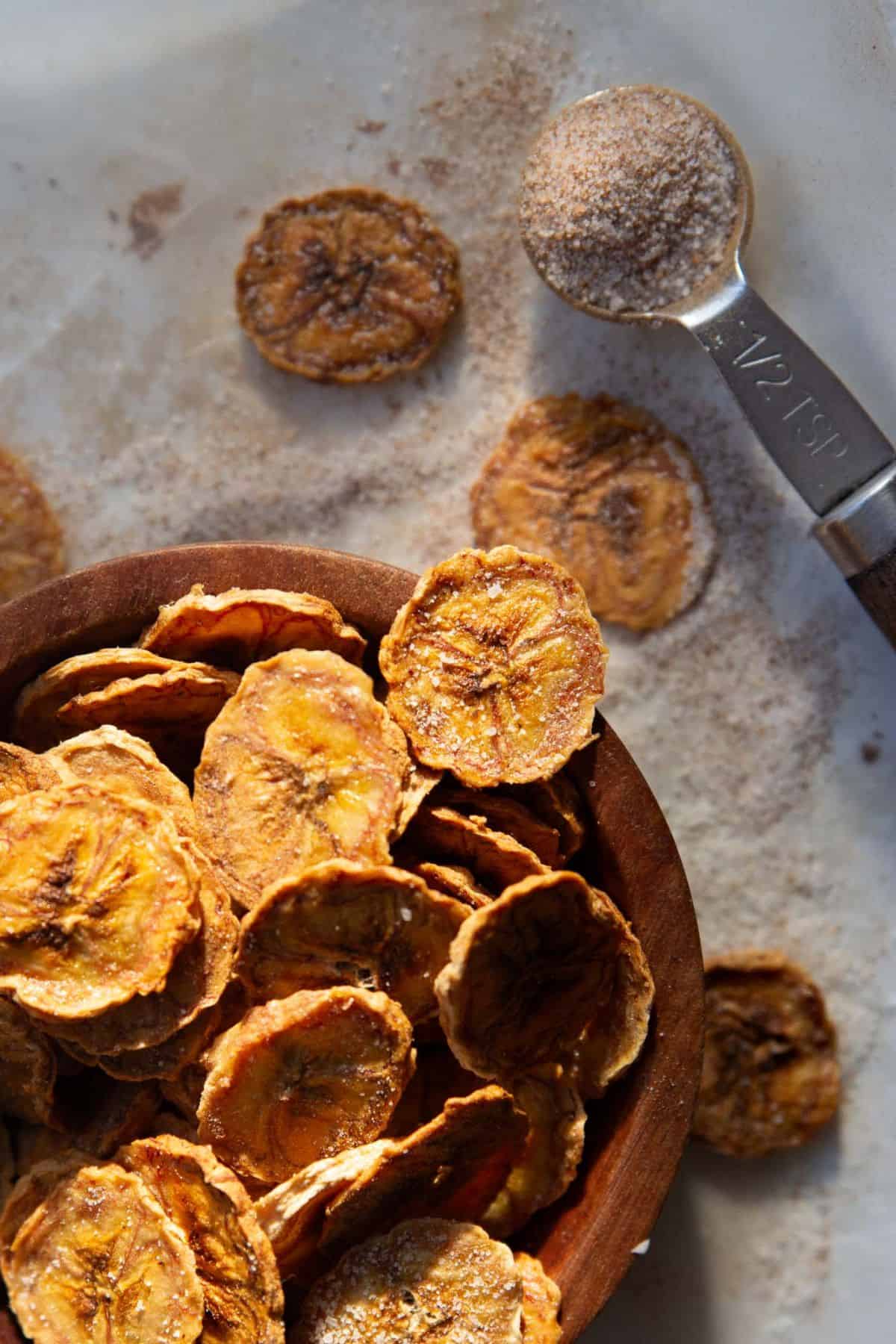 Crispy air fryer banana chips coated in homemade cinnamon sugar.