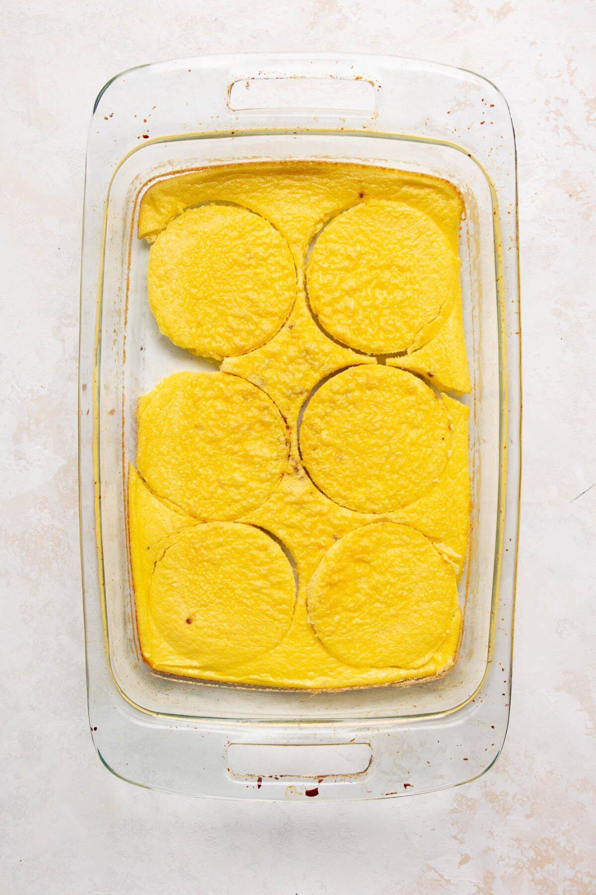 Fluffy baked egg slab cut into rounds for breakfast sandwiches.