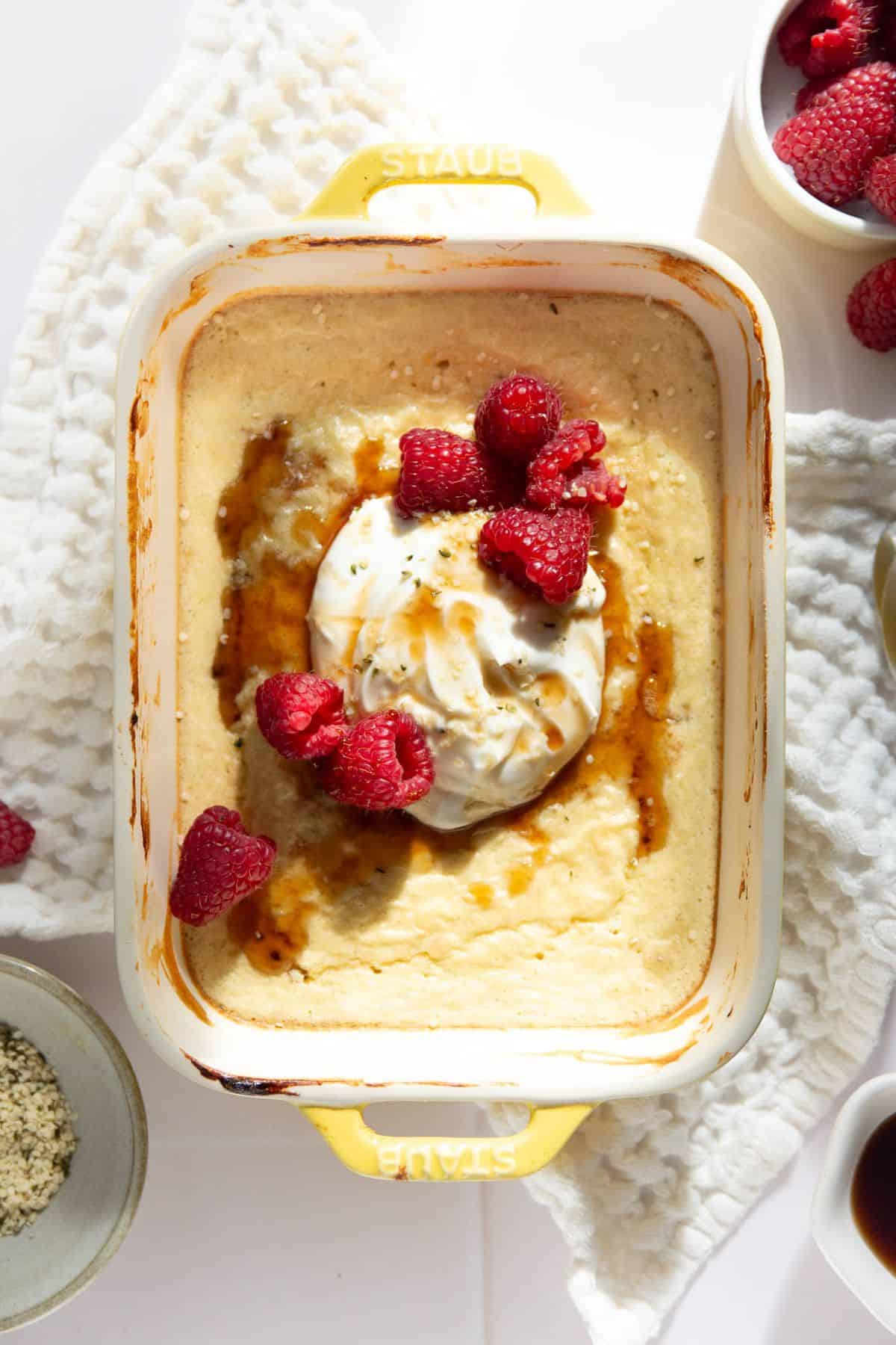 High protein pancake bowl topped with a dollop of Greek yogurt, fresh raspberries, and a drizzle of maple syrup.